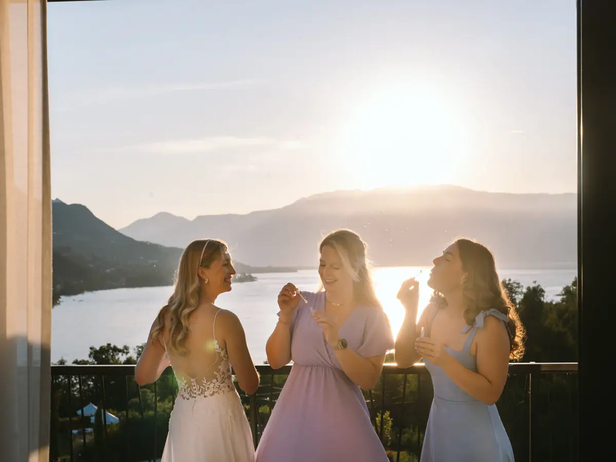 Eine Gruppe von Frauen in festlichen Kleidern, die Seifenblasen pusten.