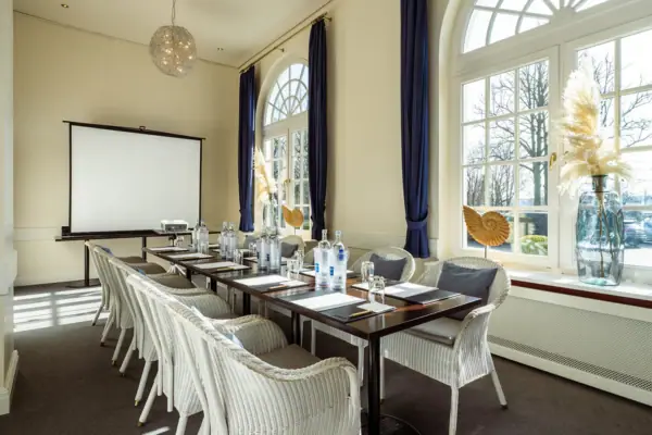 A-ROSA Veranstaltungsraum Passatzimmer Ein Zimmer im A-ROSA Travemünde mit einem Tisch und Stühlen.