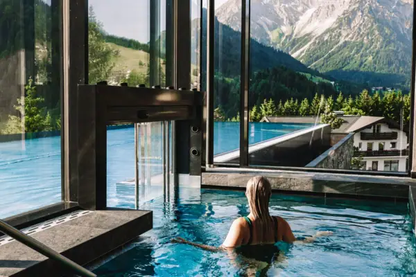 Eine Frau in einem Pool mit Blick auf Berge und Bäume
