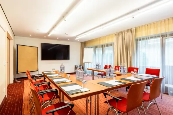 A-ROSA Veranstaltungsraum Impuls Ein Zimmer im A-ROSA Travemünde mit einem Tisch und Stühlen.
