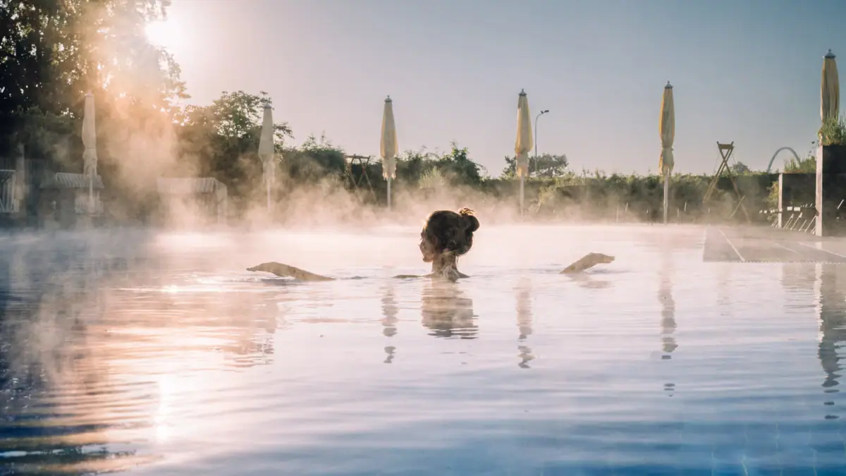 Eine Frau in einem Pool mit einer heißen Quelle.