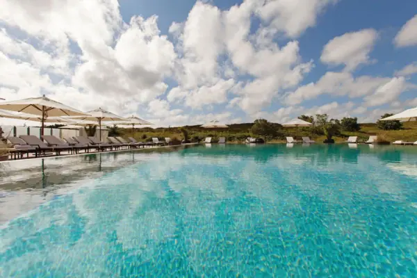 Ein Pool mit Liegestühlen und Sonnenschirmen.