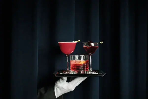 Ein Tablett mit verschiedenen Cocktails wird serviert.