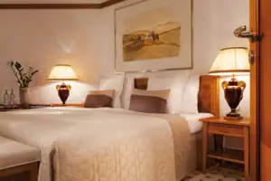 Ein Bett mit Lampen und einem Gemälde an der Wand.
