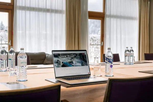 Raum Kirchhoff Laptop auf einem Tisch mit Wasserflaschen und einem Fenster im Hintergrund.