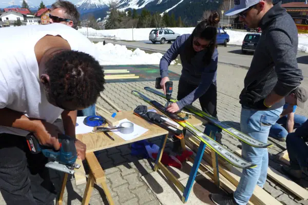 Eine Gruppe von Menschen arbeitet an Skiern.