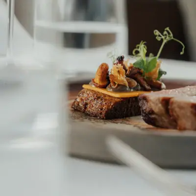Angerichtetes Steak Ein Teller mit Essen auf einem Tisch mit Weinglas.