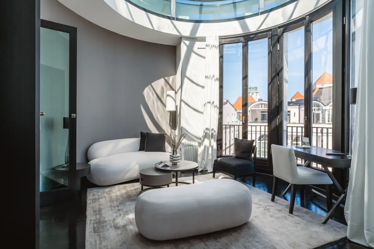 Wohnzimmer mit Glasdecke und großem Fenster, ausgestattet mit Möbeln und einem Couchtisch.