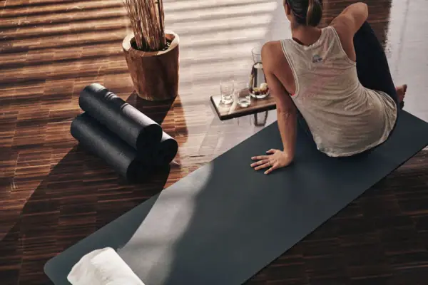 Frau sitzt auf Yoga Matte