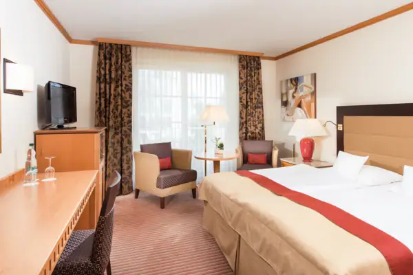 Ein Zimmer mit einem Bett und einem Fernseher.