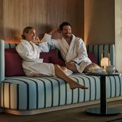Eine Frau und ein Mann sitzen beim Day SPA im Straubinger Grand Hotel im Bademantel in einer gemütlichen Sitzecke.