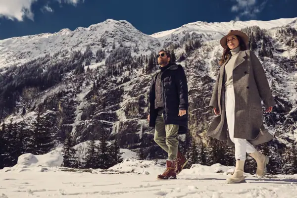 Ein Mann und eine Frau gehen im Schnee spazieren.