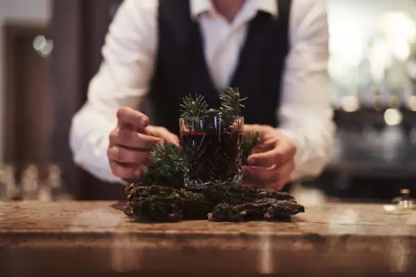 Eine Person hält ein Glas mit einem Getränk.