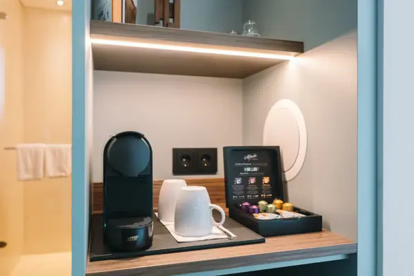 Kaffeemaschine und Kaffeetassen auf einem Regal