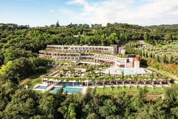 A-ROSA Hotel am Gardasee Außenansicht Ein Gebäude mit einem Pool, umgeben von Bäumen.