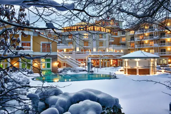 A-ROSA Heringsdorf Ein Gebäude mit einem Pool im Schnee, umgeben von winterlicher Landschaft.