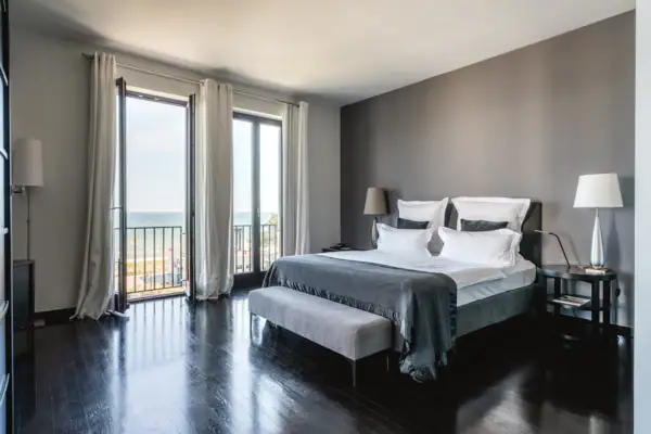 Schlafzimmer mit großem Fenster und Blick auf das Meer.
