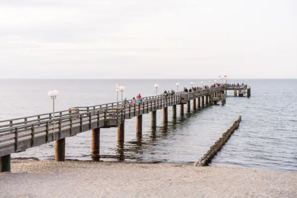 Eine Gruppe von Menschen auf einem Pier im Freien.