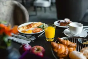 Frühstück Ein Teller mit Essen und ein Glas Saft auf einem Tisch.