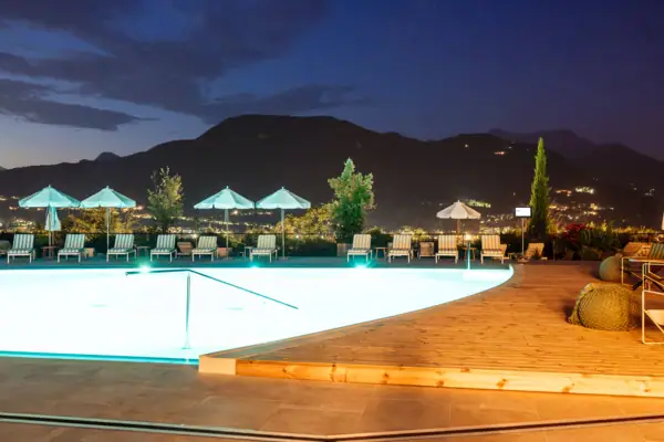 Ein Swimmingpool mit Liegestühlen und Sonnenschirmen im Hintergrund.