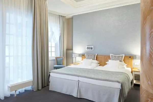 Ein Zimmer mit zwei Betten und einer Lampe.