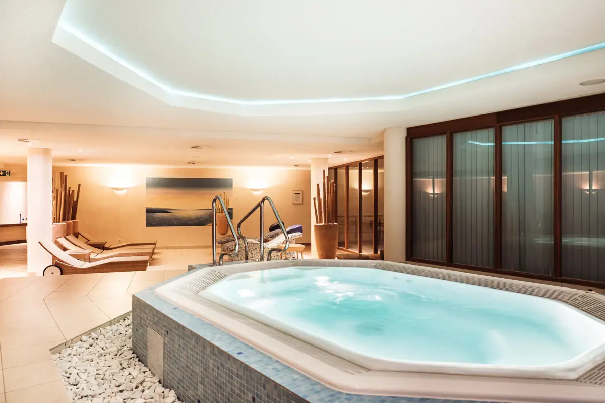 Whirlpool in einem SPA Bereich und Entspannungsliegen im Hintergrund.