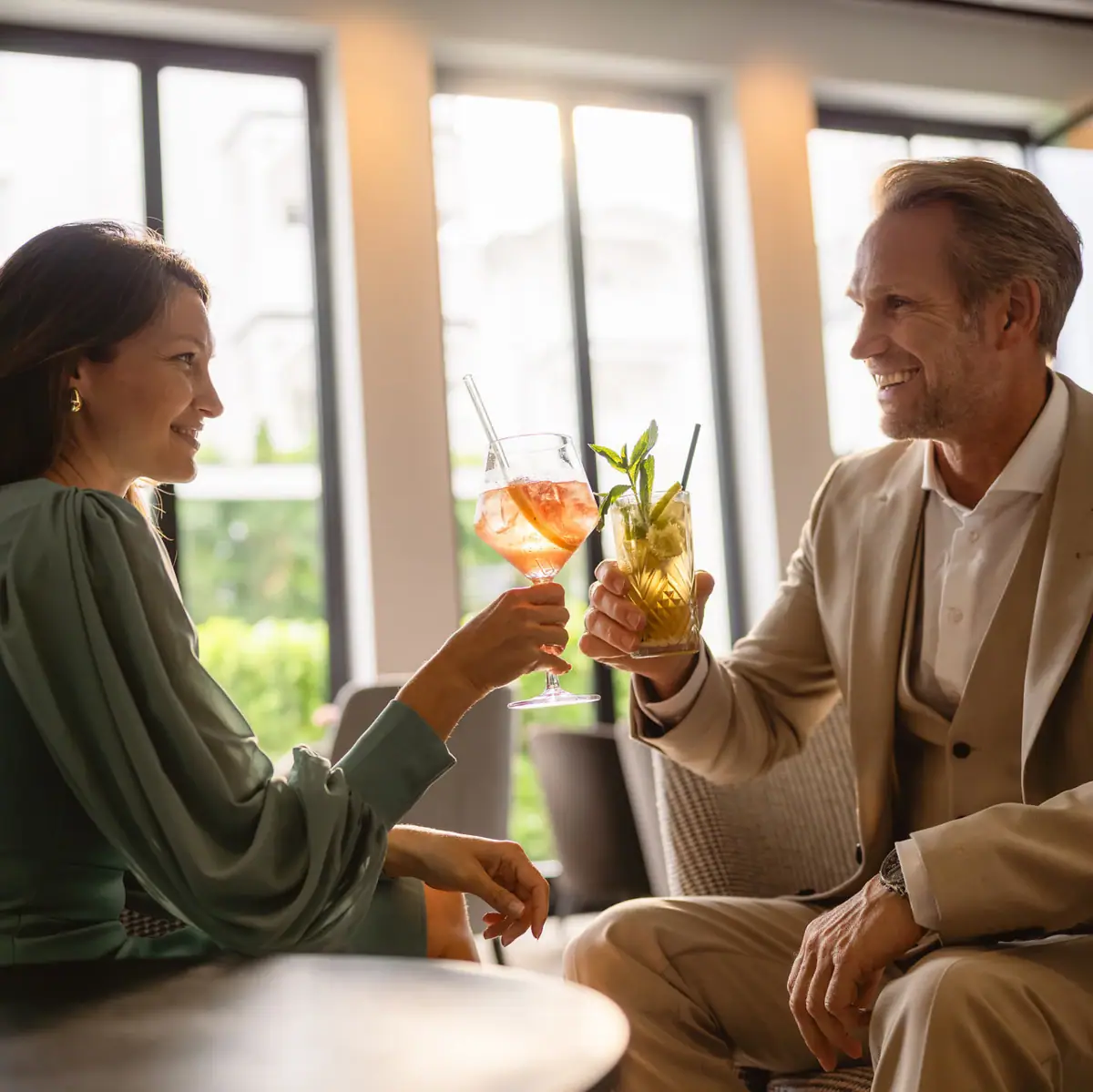 Ein Mann und eine Frau halten Getränke in der Hand.