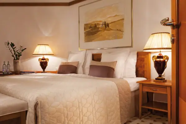 Zimmer Ein Bett mit Lampen und einem Gemälde an der Wand.