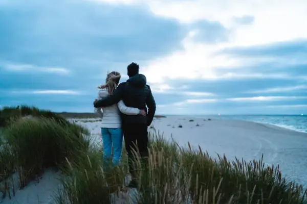 Dünen Ein Mann und eine Frau stehen am Strand.