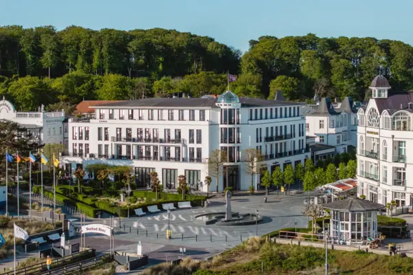 Ein weißes Gebäude mit Bäumen im Hintergrund.