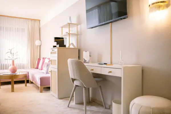 Ein Zimmer mit einem Schreibtisch und einem Fernseher.