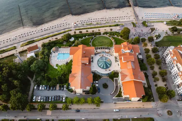Luftaufnahme eines Gebäudes mit Pool und Bäumen am Wasser
