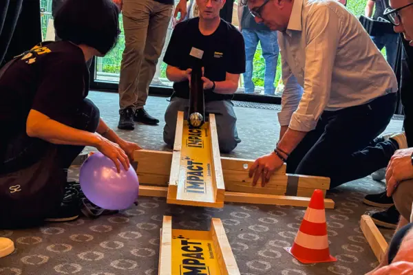 Eine Gruppe von Menschen spielt mit einer Murmelbahn