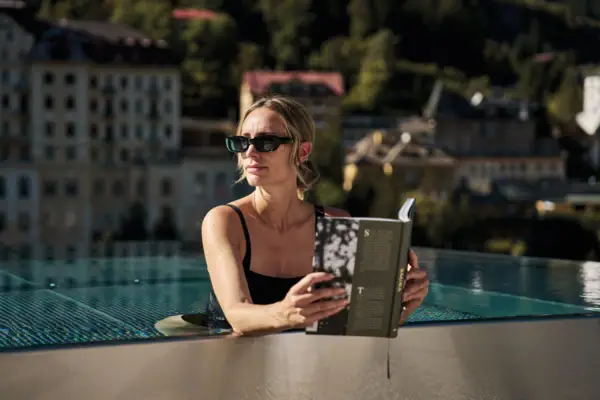 Eine Frau liest ein Buch in einem Schwimmbecken.