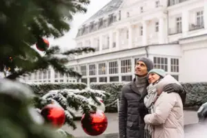 Ein Mann und eine Frau stehen vor einem Weihnachtsbaum.