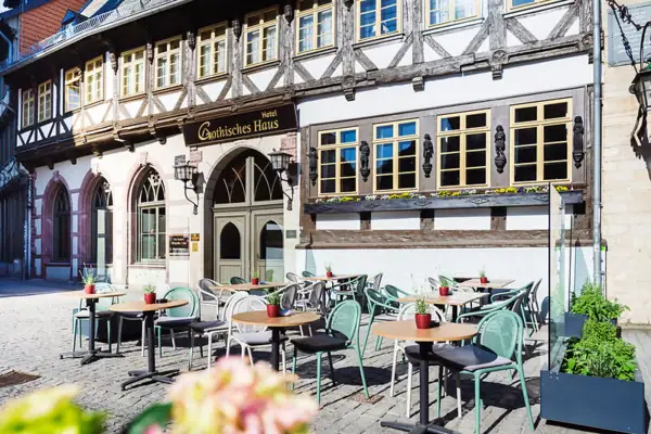 A-ROSA Gothisches Haus Ein Gebäude mit Tischen und Stühlen im Freien.
