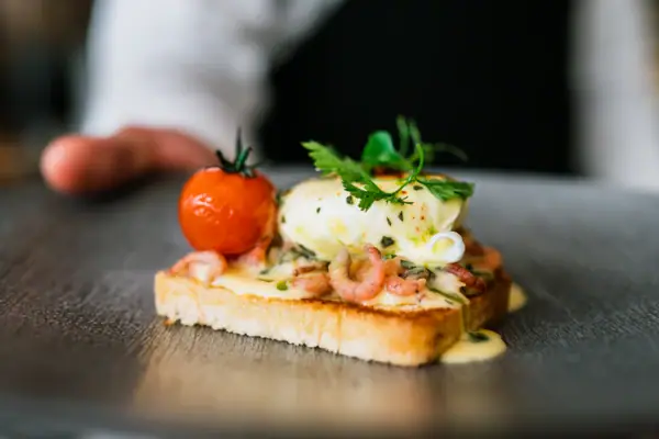 Nahaufnahme von Egg Benedict mit kulinarischer Präsentation.