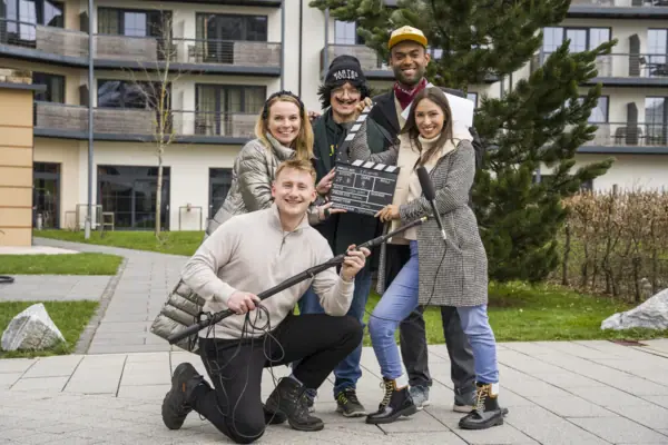 Eine Gruppe von Menschen posiert lächelnd für ein Foto im Freien.