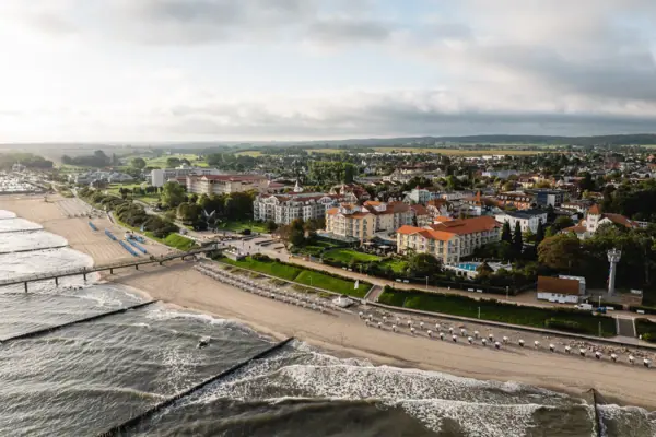Strand mit Gebäuden und Wasser aus der Vogelperspektive.