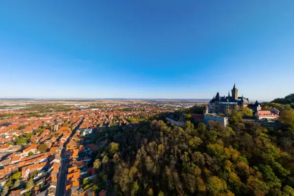 Stadtansicht mit einem Schloss auf einem Hügel.