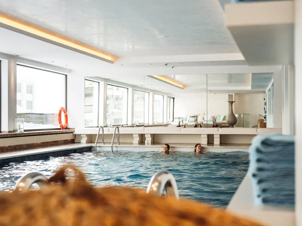 Pool im Thurnher’s Alpenhof Personen im Pool vom Thunher’s Alpenhof mit großem Fenster. auf der linken Seite