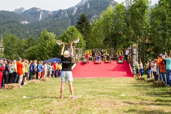 Eine Frau hält ein Skateboard in die Luft.