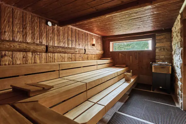 Holzsauna mit Fenster und Ofen.