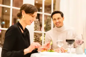 Ein Mann und eine Frau sitzen an einem Tisch mit Weingläsern.