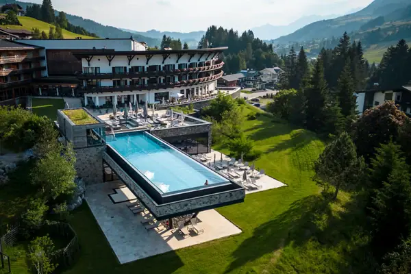 Außenpool eines Hotels mit Blick auf Bäume und Himmel.
