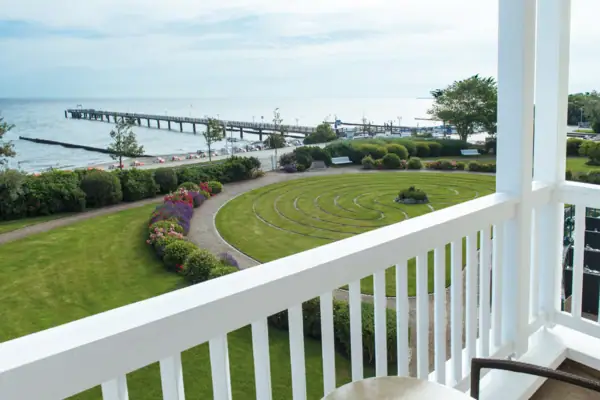 Blick auf einen Garten und einen Pier von einem Balkon aus.
