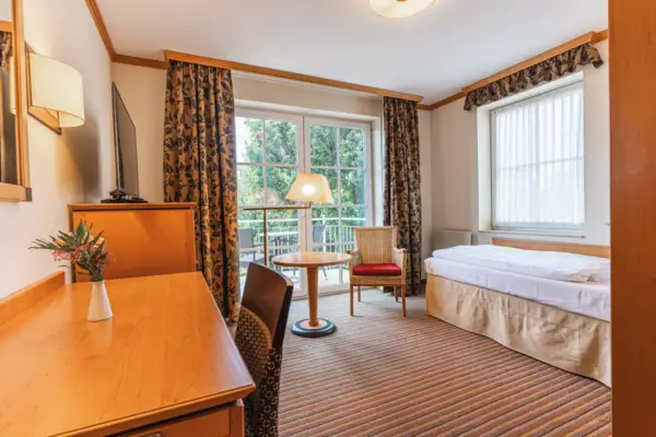 Hotelzimmer mit Bett, Schreibtisch und Stuhl.