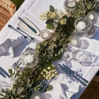 Eventlocation A-ROSA Ostseehotel Kühlungsborn Ein Tisch mit weißer Tischdecke, Kerzen und Blumen.