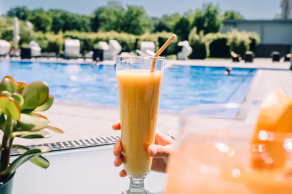 Eine Person hält ein Glas Orangensaft.