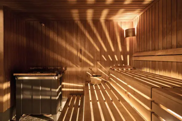 Holzsauna mit Sonnenlicht, das durch die Wände scheint